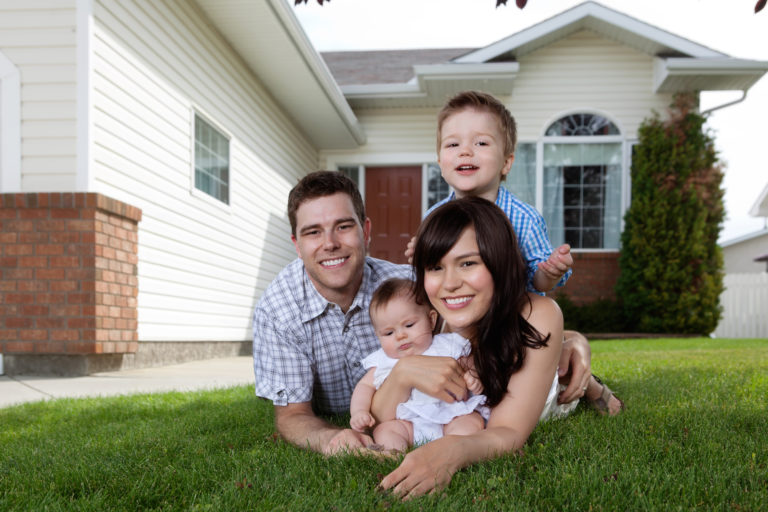 Family Laying on Grass in Front of Home with Home Insurance in Grand Rapids, OH