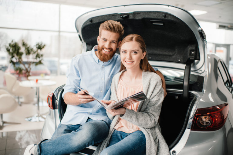 Couple Sitting on Car Trunk with Car Insurance in Toledo, OH