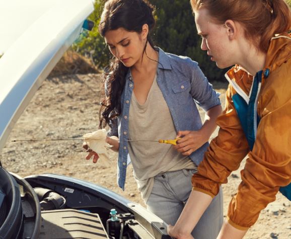 Two women looking under the hood of a car with auto insurance in Perrysburg, OH