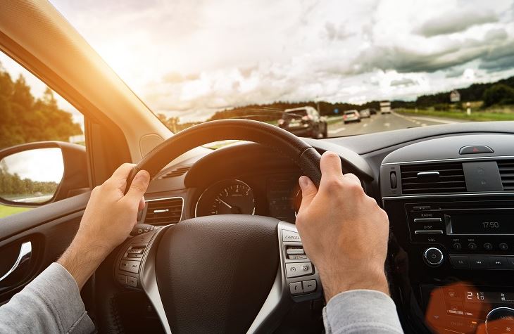 Man Holding Steering Wheel in car after receiving insurance from an Insurance Agency in Delta, OH