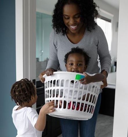 Mom and Kids with Laundry Basket Smiling after receiving insurance from and Insurance Agency in Monclova, OH