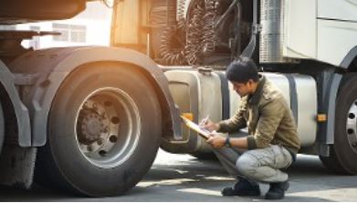 Trucker Inspecting Truck for Commercial Trucking Insurance in Waterville, OH